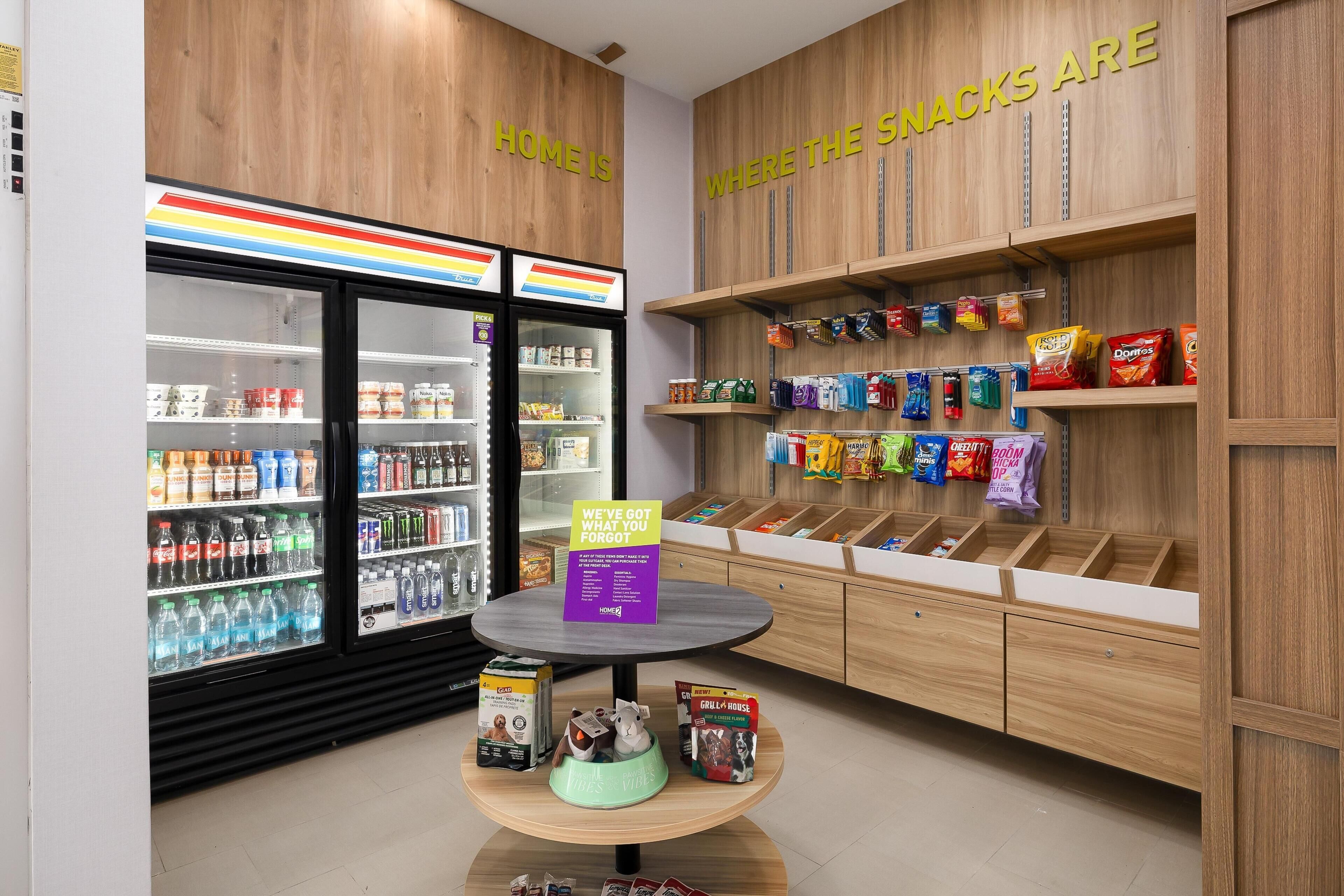 A snack display area with various packaged snacks and a refrigerated section with beverages.
