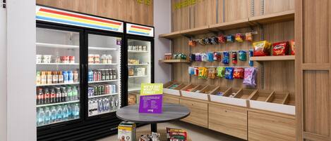A snack display area with various packaged snacks and a refrigerated section with beverages.