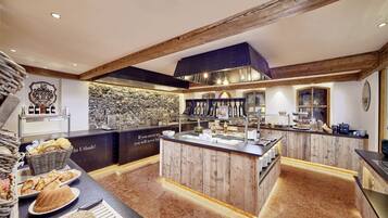 A breakfast bar with a stone wall backdrop, wooden beams, and a variety of breakfast items.