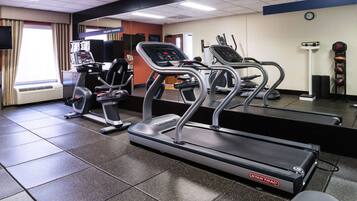 A gym with treadmills, a stationary bike, and a rowing machine.