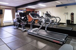 A gym with treadmills, a stationary bike, and a rowing machine.