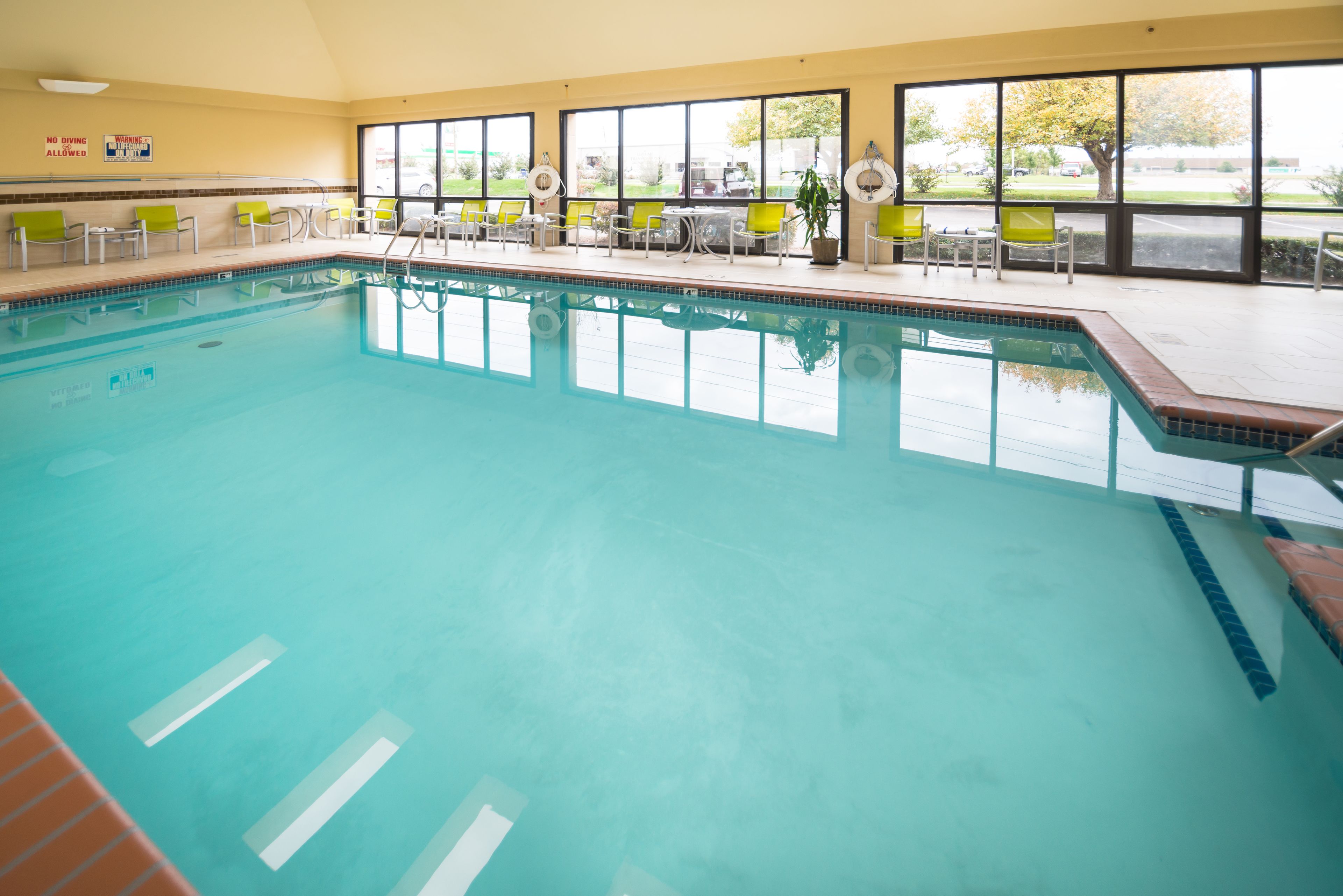 Una piscina techada, sillones reclinables de piscina