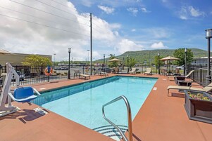 Una piscina al aire libre, sillones reclinables de piscina