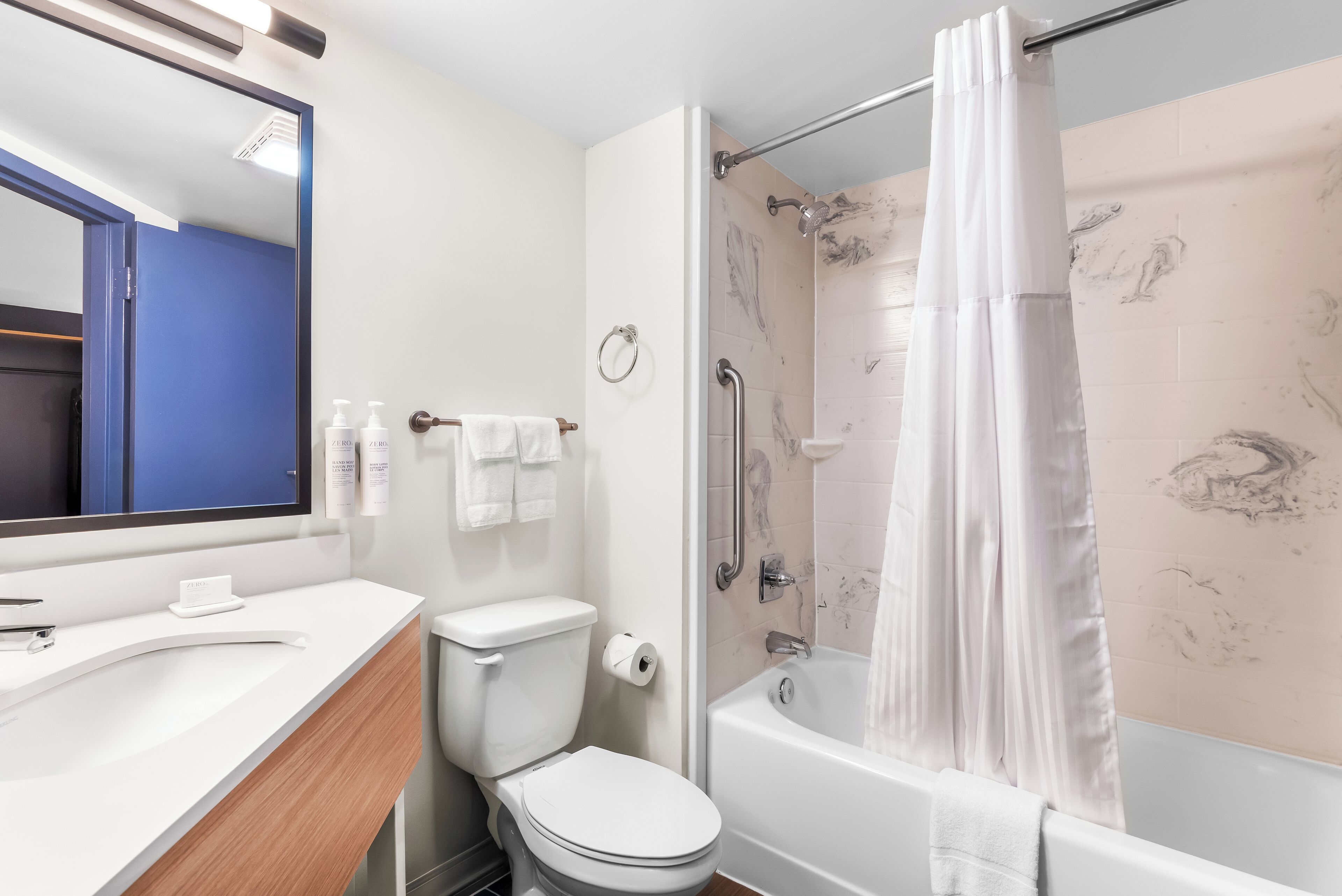 A modern bathroom with a shower, toilet, and sink.