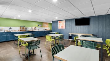 A modern cafe interior with multiple tables and chairs, a coffee machine, and a menu board.