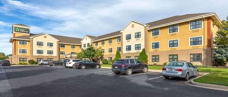 A multi-story hotel with a parking lot in front.