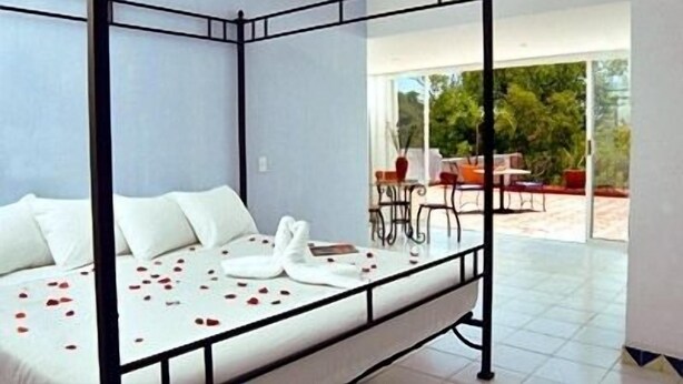 Une chambre moderne avec un lit à baldaquin et une porte vitrée donnant sur un patio extérieur.