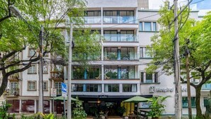 Un immeuble à plusieurs étages, avec un restaurant au rez-de-chaussée et une enseigne bien visible indiquant la présence d’un hôpital.