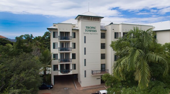A multi-story building with balconies and a sign reading "Tropic Towers Holiday Apartments". - Tropic Towers Apartments (Cairns North)