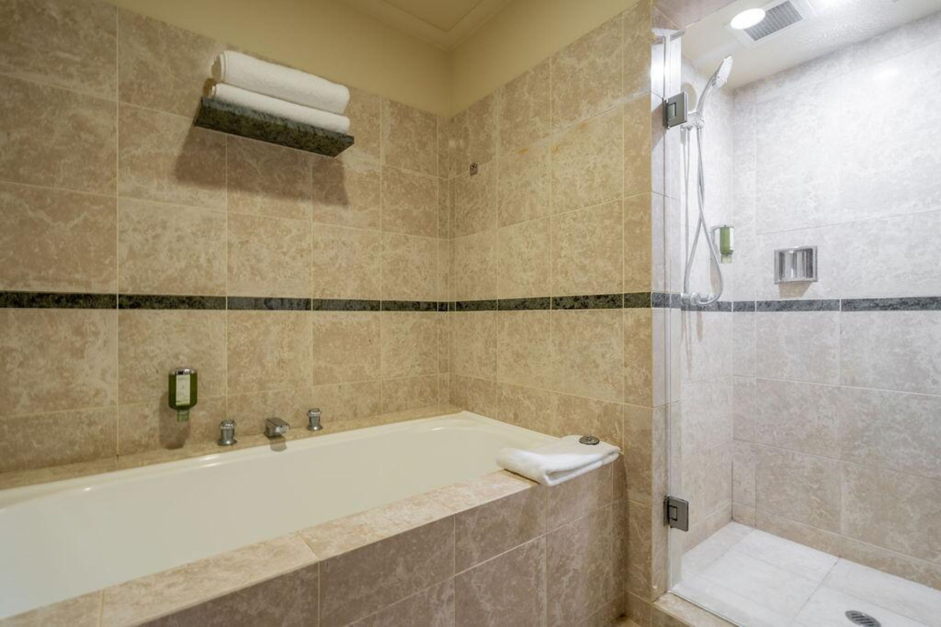 A bathroom with a bathtub, a shower, and a towel rack.