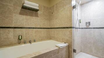 A bathroom with a bathtub, a shower, and a towel rack.