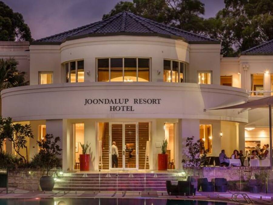 The exterior of Joondalup Resort Hotel with a pool area and outdoor seating.