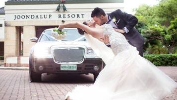 A wedding scene with a car in front of Joondalup Resort.