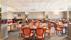 A spacious dining area with multiple tables and chairs, a bar area, and a counter with a cash register. - Comfort Hotel Dandenong (Dandenong)