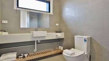 A modern bathroom with a toilet, sink, and shower area.