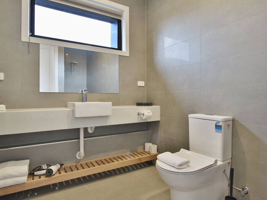 A modern bathroom with a toilet, sink, and shower area.