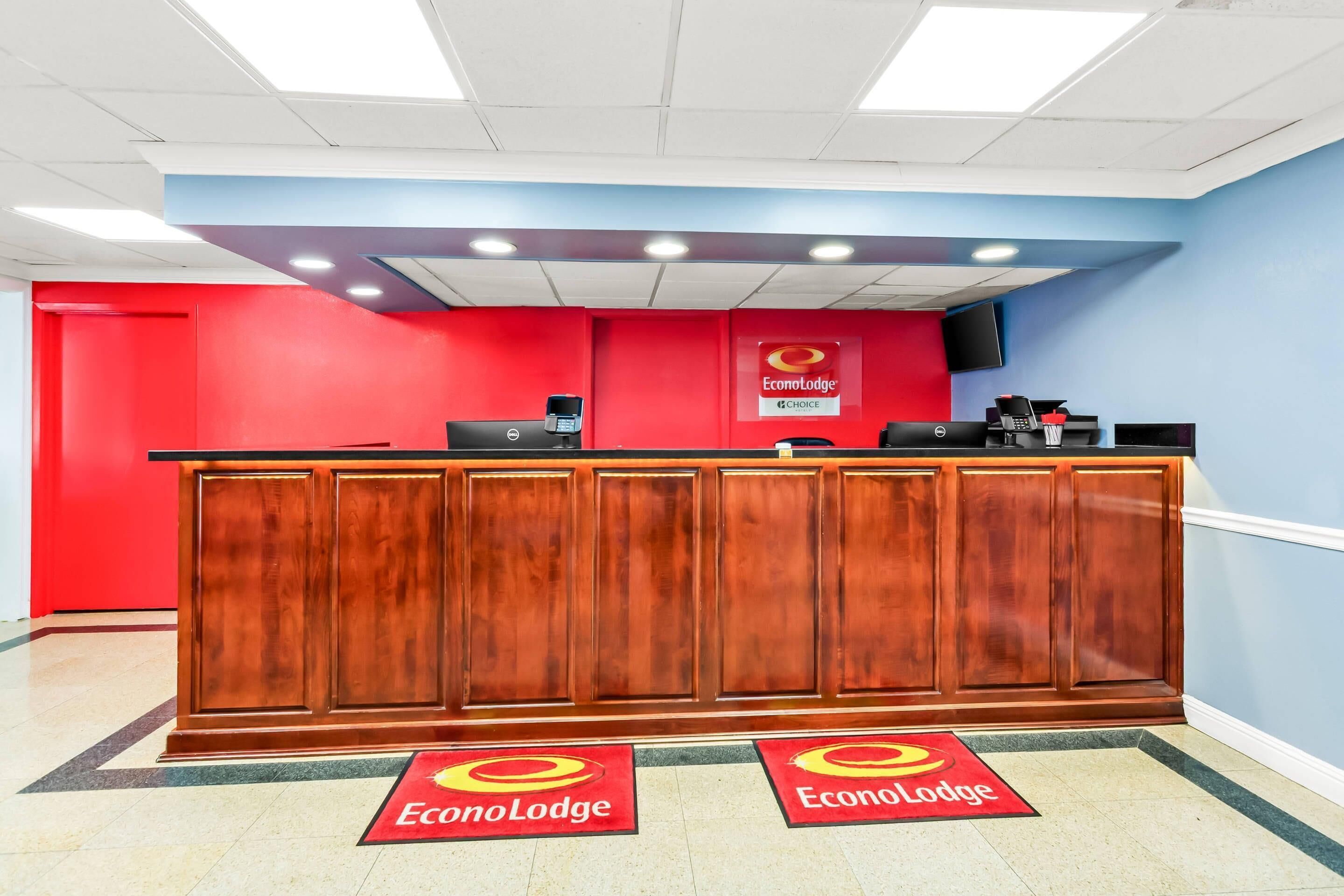 A reception desk with a red and blue color scheme, a Dell computer, and a coffee machine.