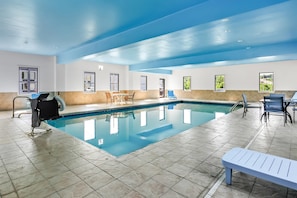 Una piscina techada, sillones reclinables de piscina