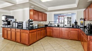 A modern kitchen with a large island, built-in appliances, and wooden cabinetry. - Econo Lodge Mt Hope - Beckley North (Mount Hope)