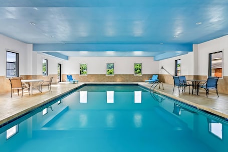 Una piscina techada, sillones reclinables de piscina