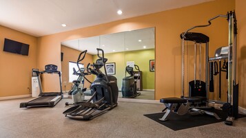 Un gimnasio con cintas de correr, elípticas y máquinas de pesas.