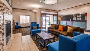 A lobby with a fireplace, blue armchairs, a brown sofa, and a patterned carpet. - Best Western Troy Hotel (Troy)