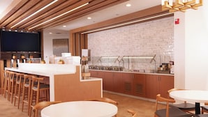A modern kitchen with a brick backsplash, wooden bar counter, and bar stools. - Residence Inn Charleston Riverview (Charleston)