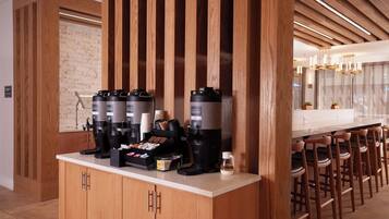 Een moderne keuken met een koffiehoek, inclusief meerdere koffiezetapparaten en een selectie koffiecups.