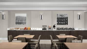 A modern dining area with a long counter, multiple seating options, and artwork on the walls.