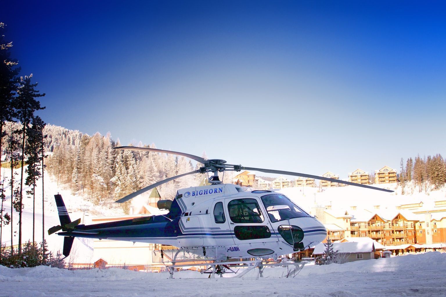 Un helicóptero con el texto "BIGHORN" estacionado sobre una superficie nevada.