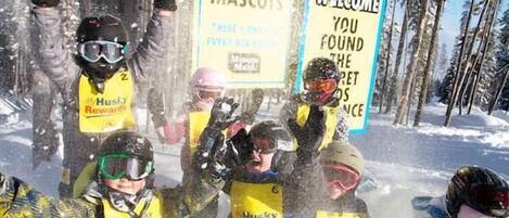 A group of people in a snowy outdoor setting with signs that read "FIND THE MASCOTS" and "Minute Maid."