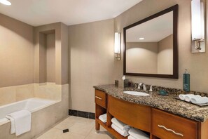 Un baño moderno con bañera, lavamanos y tocador con espejo.