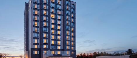 A multi-story hotel with a modern design, featuring a prominent entrance with a glass facade and a sign that reads "Courtyard by Marriott."
