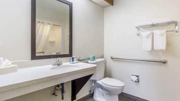 Een moderne badkamer met een wastafel, spiegel, toilet en handdoekrek.