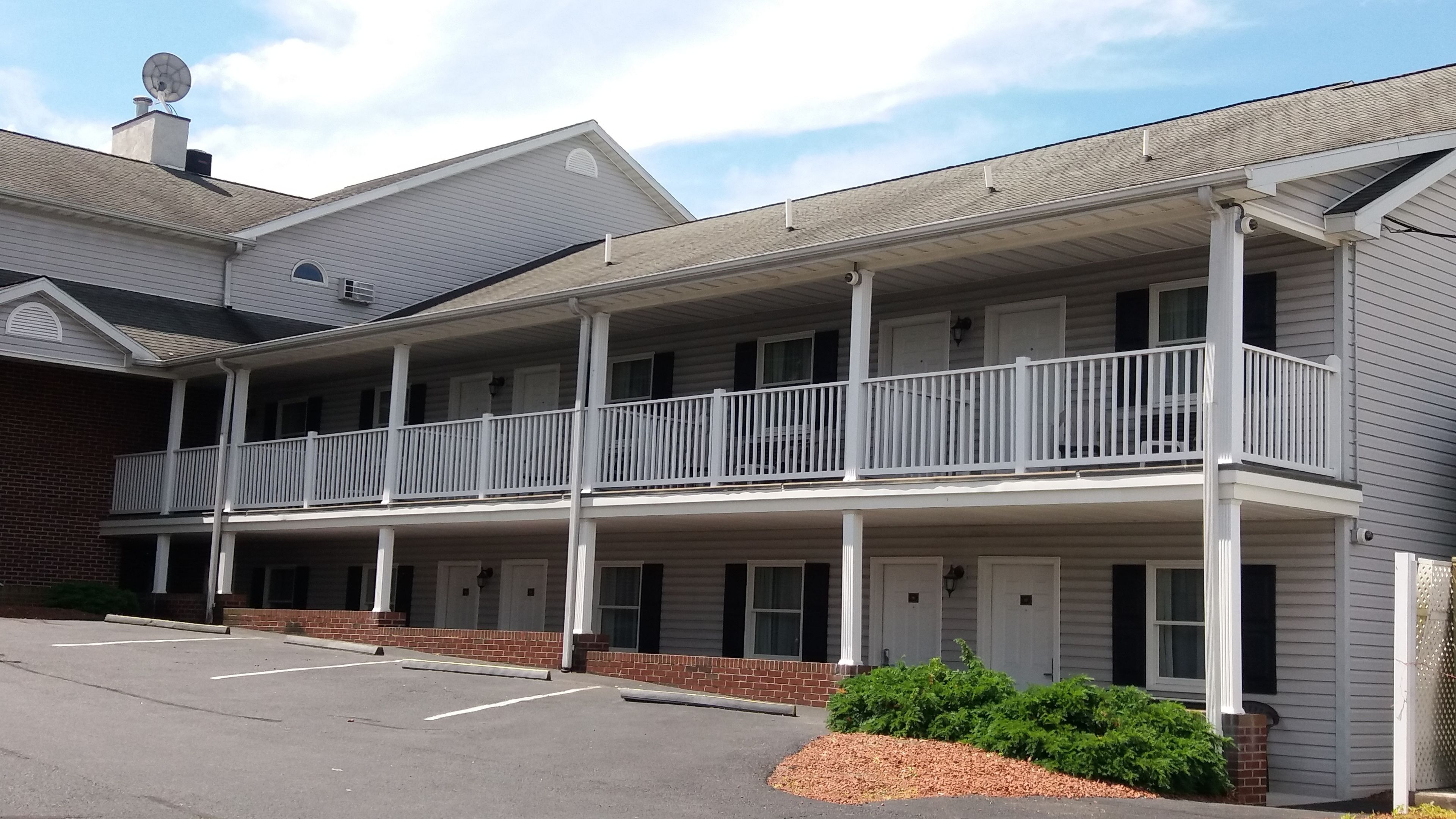 A two-story motel with a covered front porch and a parking lot.