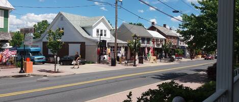 A street view with a row of buildings, including a cafe and a store with an American flag.