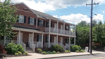 Stroll up to this charming two-story home with a welcoming front porch and a balcony overlooking lush surroundings.