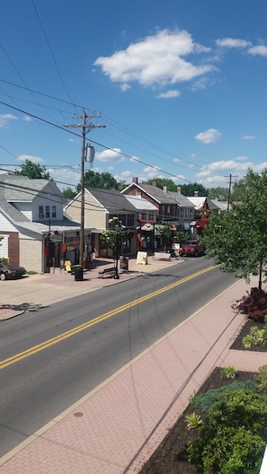 A street view with buildings, a sidewalk, and a clear sky.