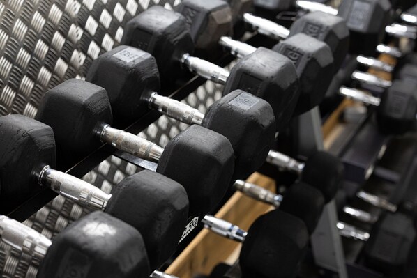 A rack of black dumbbells with weight labels.