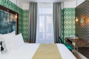 A hotel room with a bed, a desk, and a window with curtains. - The Jay Hotel by HappyCulture (Nice)