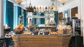 Un buffet de petit-déjeuner proposant une variété d’aliments et de boissons, notamment des viennoiseries, des fruits et des boissons diverses.