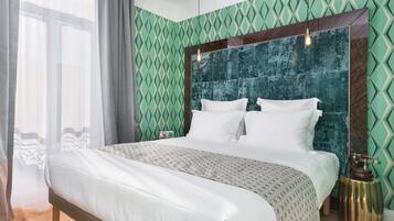 A neatly made bed with white linens, a patterned throw, and a wooden headboard.