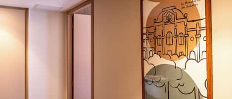 A framed artwork depicting a building with the text 'La Manufacture des Gobelins' and 'citadines' on the wall.