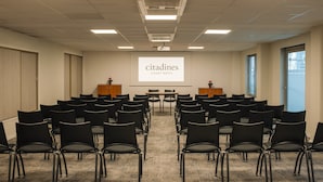 A conference room with rows of black chairs, a projector screen displaying "citadines APART HOTEL", and a carpeted floor. - Citadines Place d’Italie Paris (Paris)