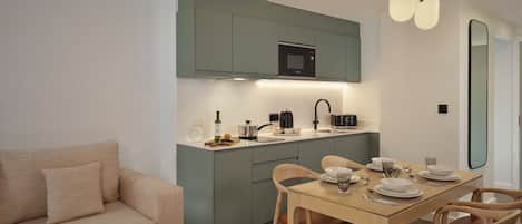 A compact living space with a kitchenette, a dining area, and a sofa.