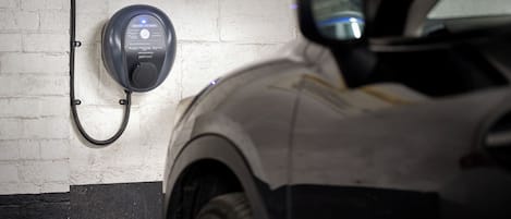 Un estacionamiento con estación de carga para vehículos eléctricos.