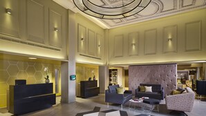 A spacious lobby with a reception desk, seating area, and a decorative ceiling. - Citadines Trafalgar Square London (London)
