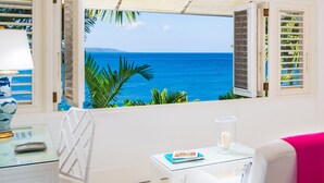 A room with a view of the ocean, a white table, a white chair, and a lamp. - Round Hill Hotel And Villas (Montego Bay)