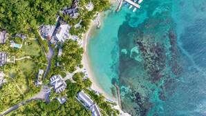 An aerial view of a resort with multiple buildings, a beach, and clear turquoise waters. - Round Hill Hotel And Villas (Montego Bay)