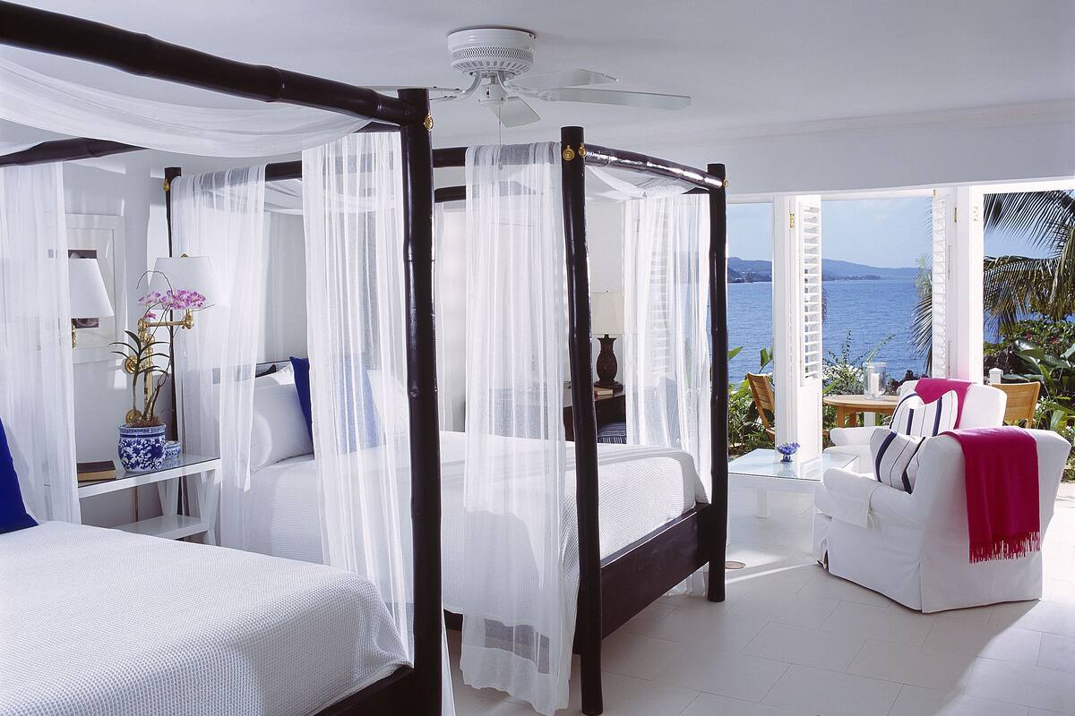 Un lit à baldaquin à quatre poteaux avec vue sur la mer.